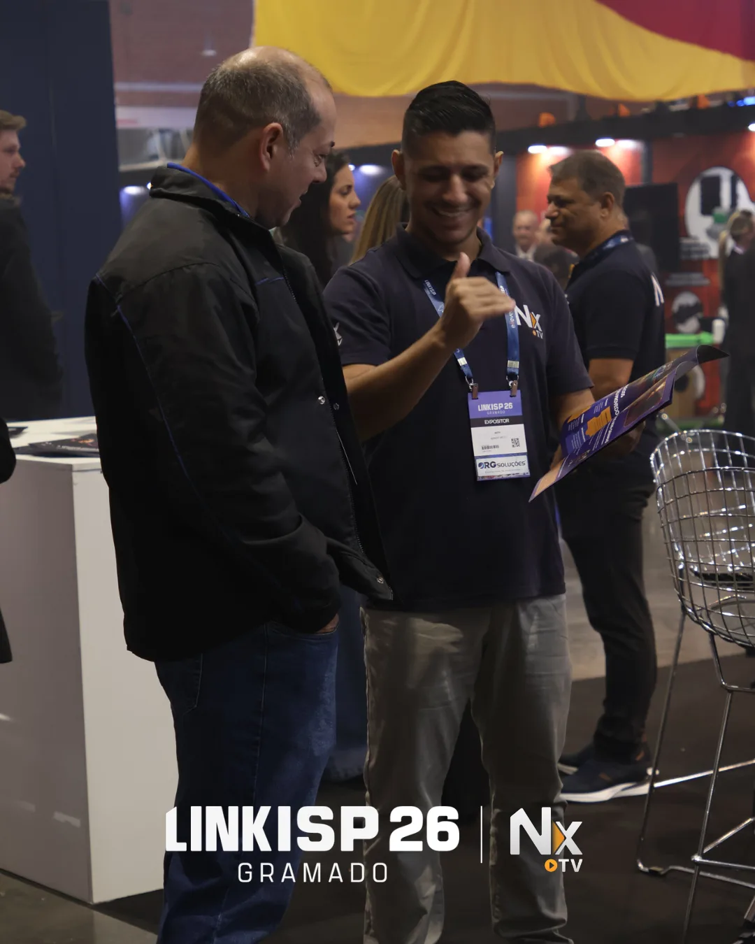 Equipe da NXTV conversa com visitante durante o LinkISP