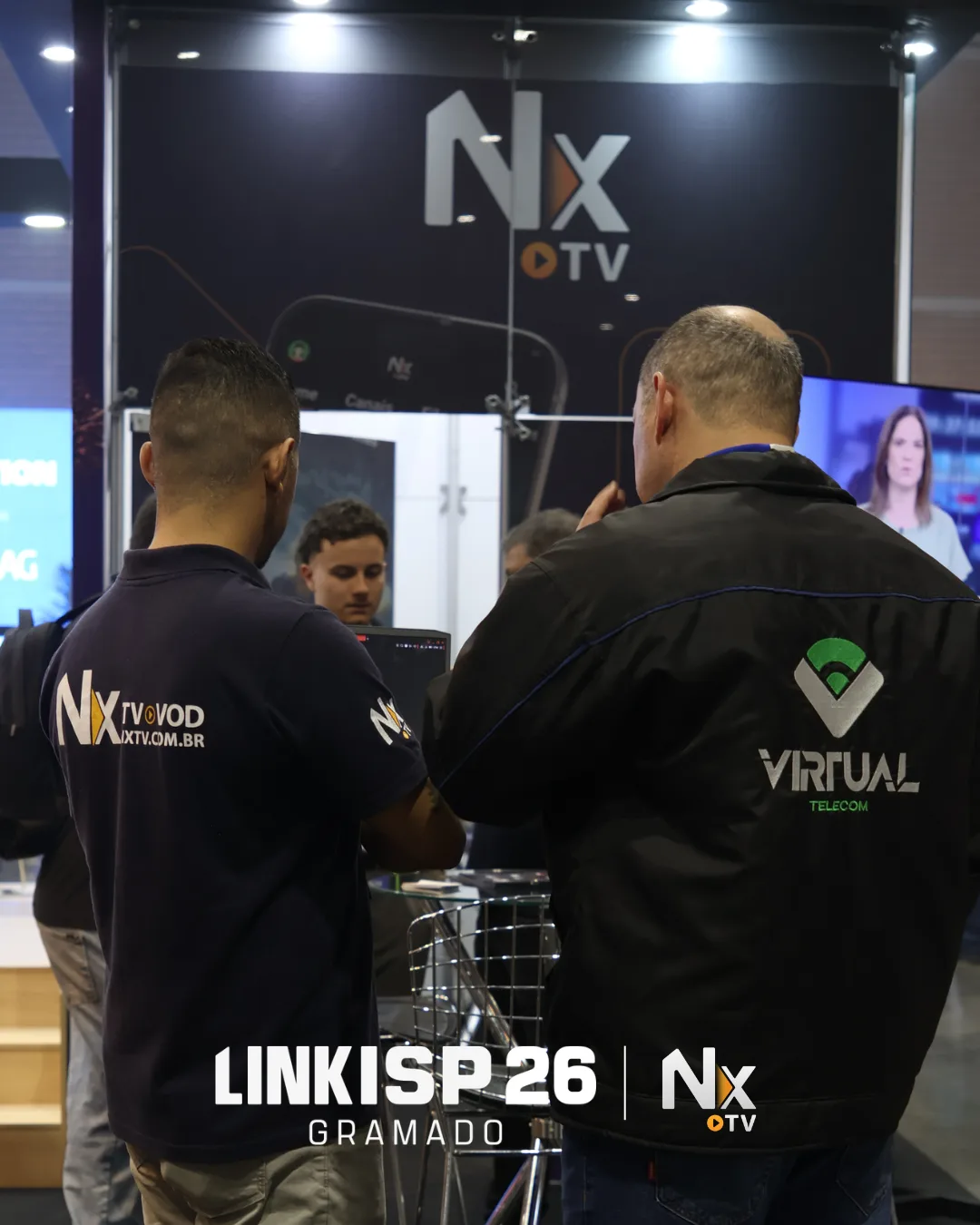 Profissional da NXTV apresenta uma solução a visitante no estande